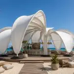Contemporary sculptural shade structure overlooking a beachfront resort.