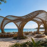 Contemporary sculptural shade structure overlooking a beachfront resort.
